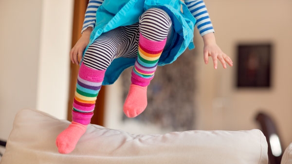 A child jumps on the sofa
