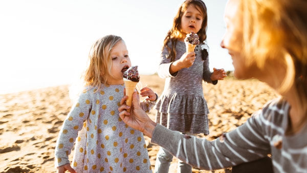 Two young girls eat ice cream